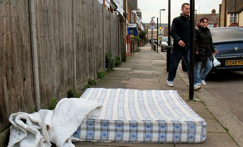 A mattress on the sidewalk.